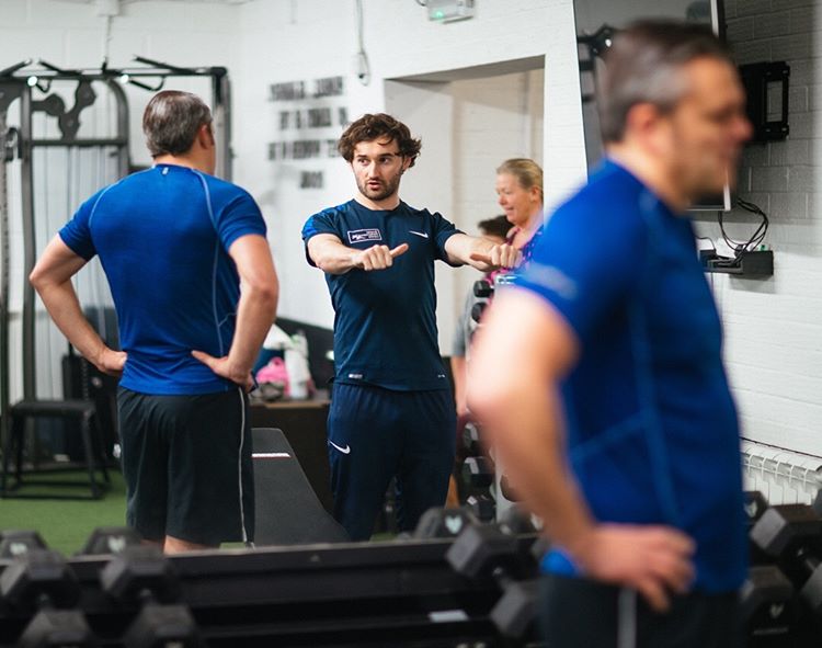 Matt demonstrating a movement to a group on the gym floor