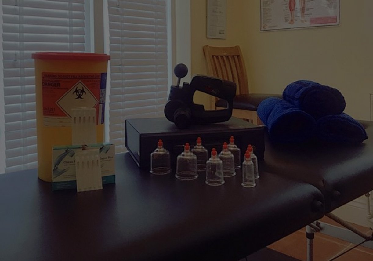 Matt's treatment room: massage table, cupping set, massage gun and navy towels